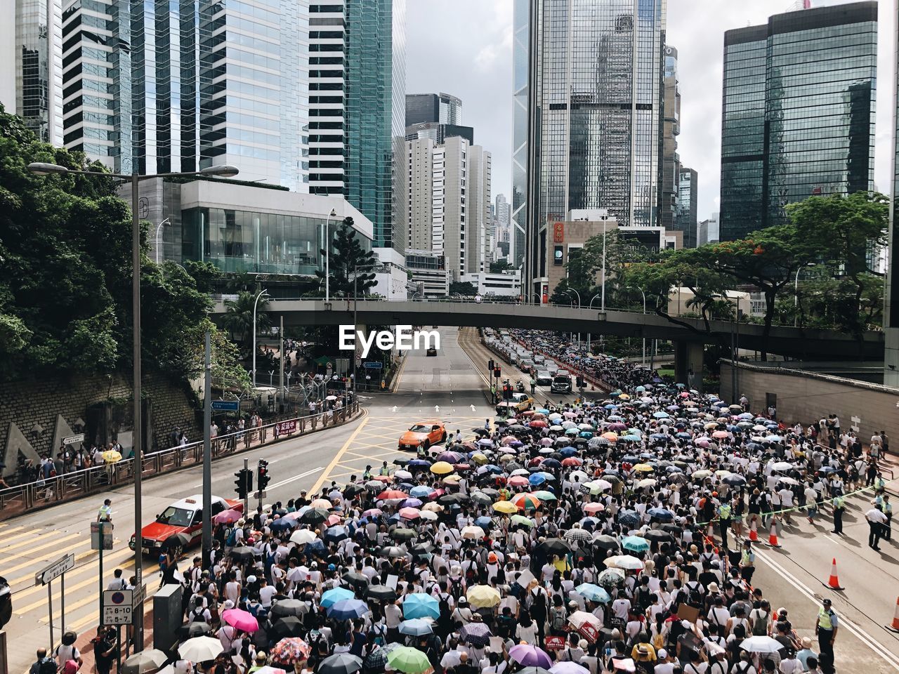 HIGH ANGLE VIEW OF CROWD ON CITY STREET AGAINST BUILDINGS