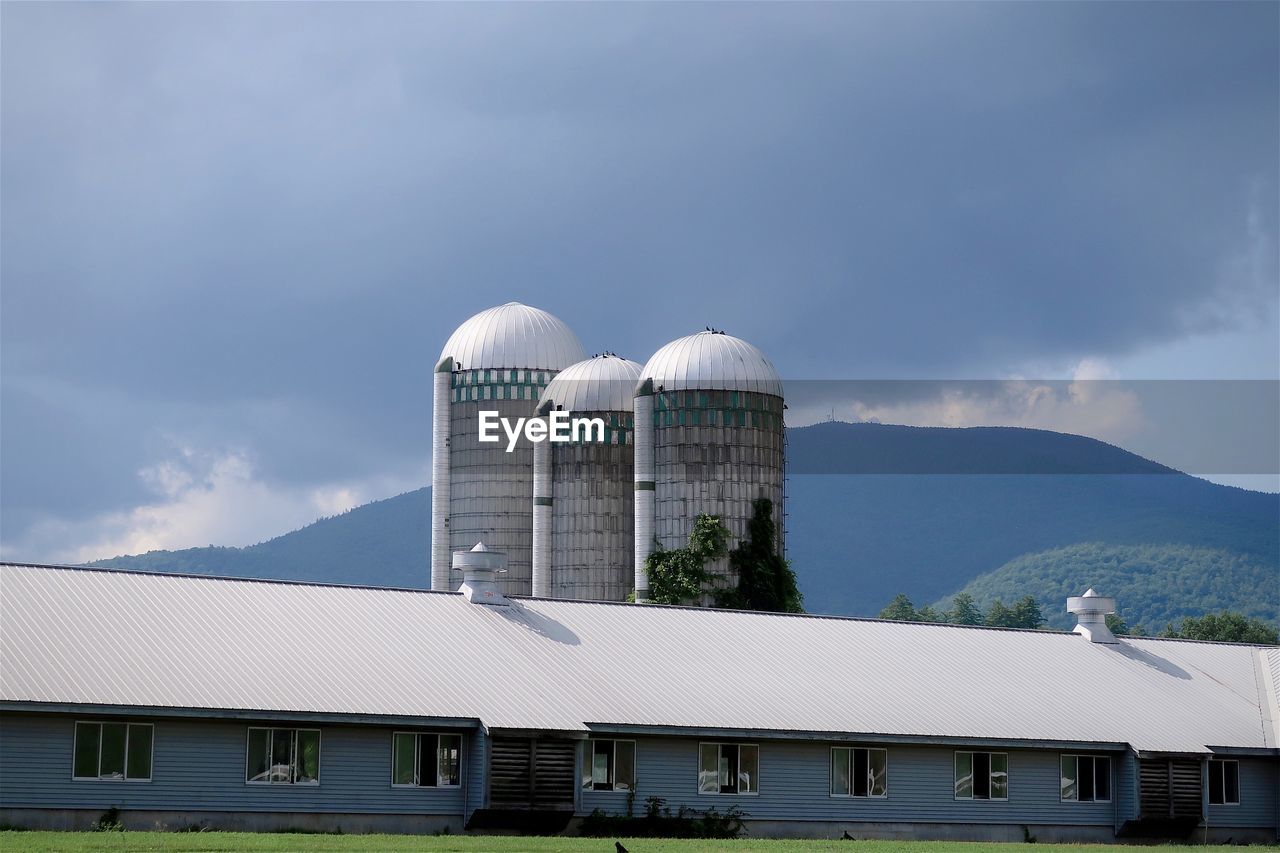 Farm and silos with mountains in the background