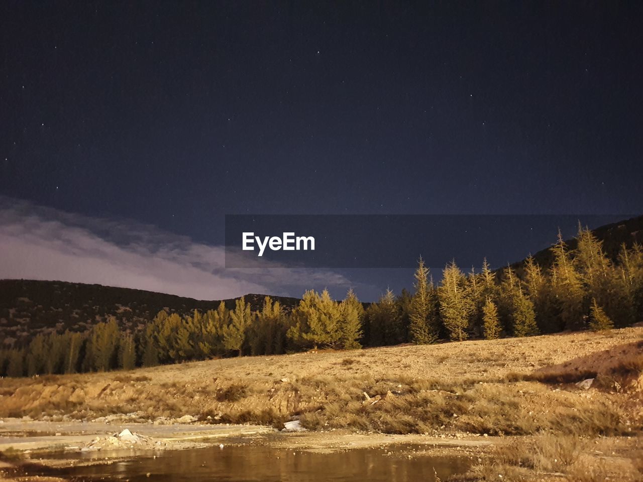 Scenic view of lake against sky at night