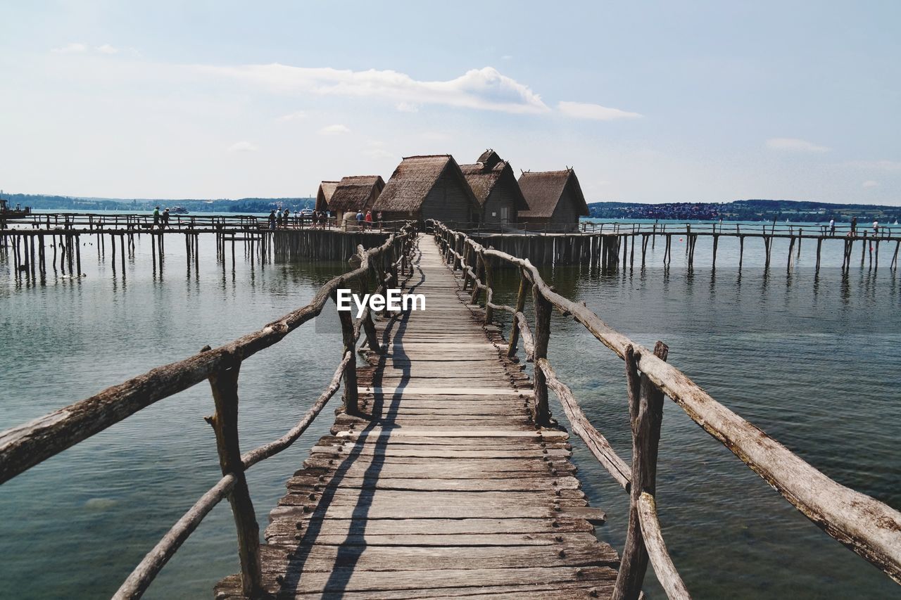 WOODEN JETTY LEADING TO PIER OVER SEA