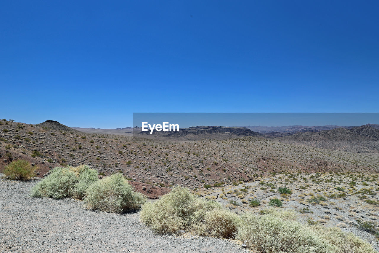 Scenic view of desert against clear blue sky