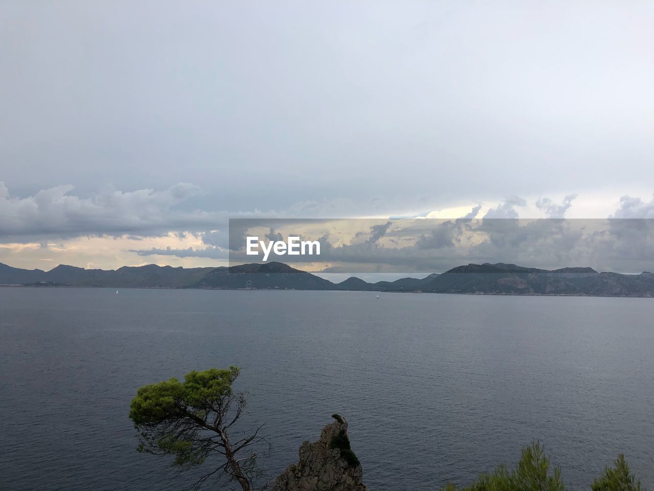 SCENIC VIEW OF SEA BY MOUNTAINS AGAINST SKY