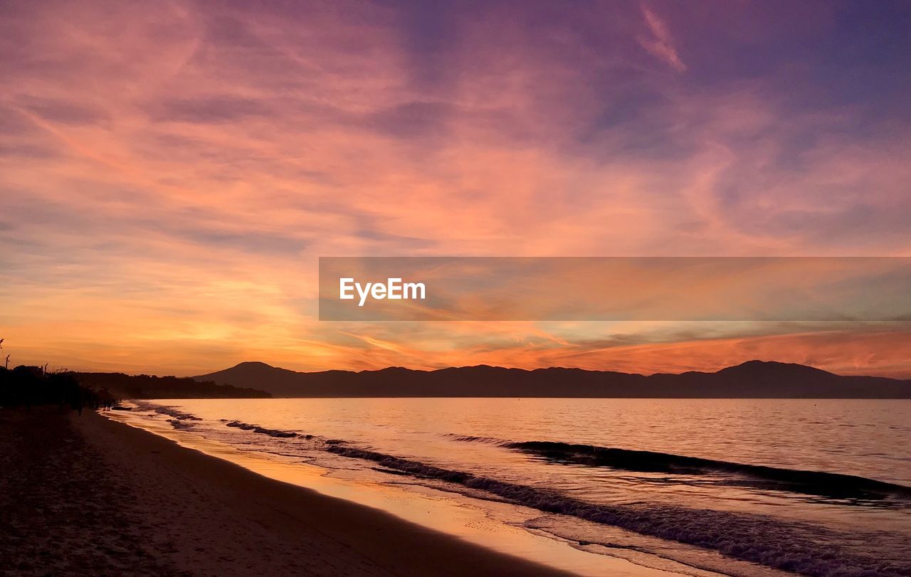 Scenic view of beach against sky during sunset