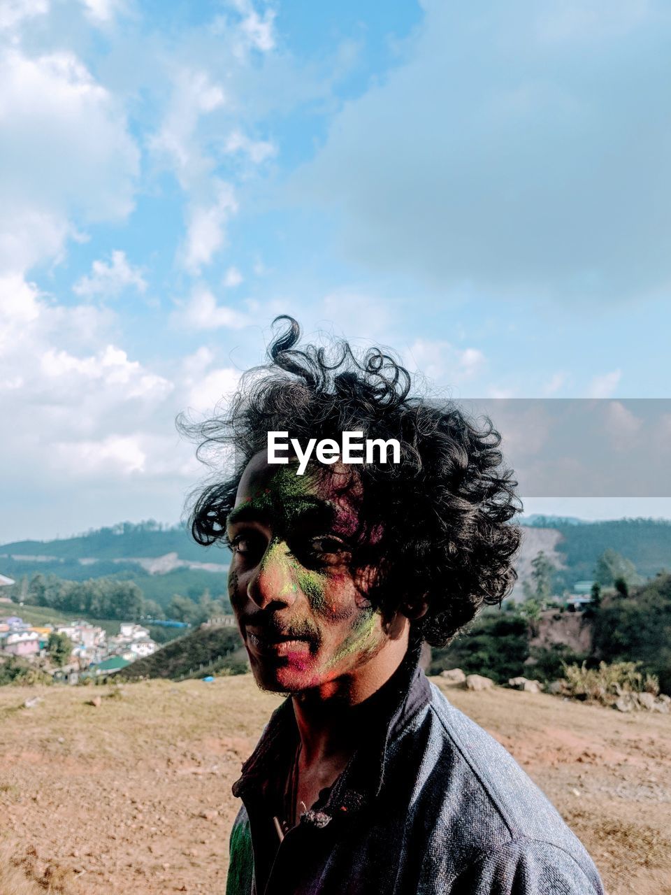 Portrait of man face covered with powder paint against sky