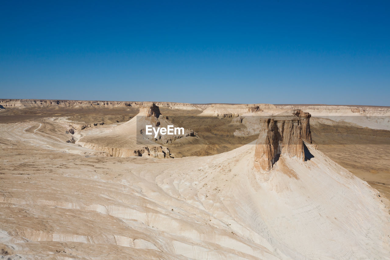 scenic view of desert against blue sky