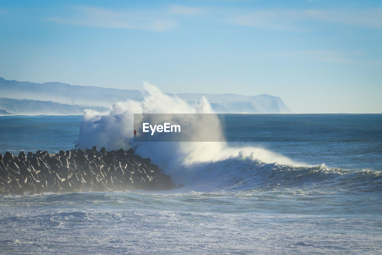 SCENIC VIEW OF SEA WAVES SPLASHING AGAINST SKY