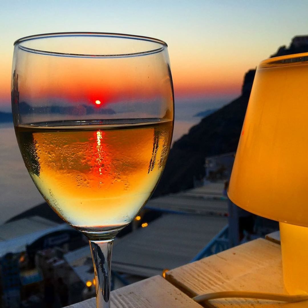 CLOSE-UP OF BEER GLASS ON TABLE AGAINST SUNSET