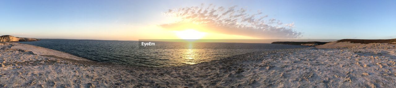 Panoramic view of beach against sky at sunset
