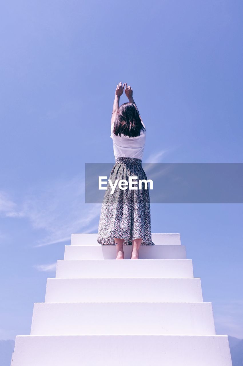 Low angle view of woman standing on staircase