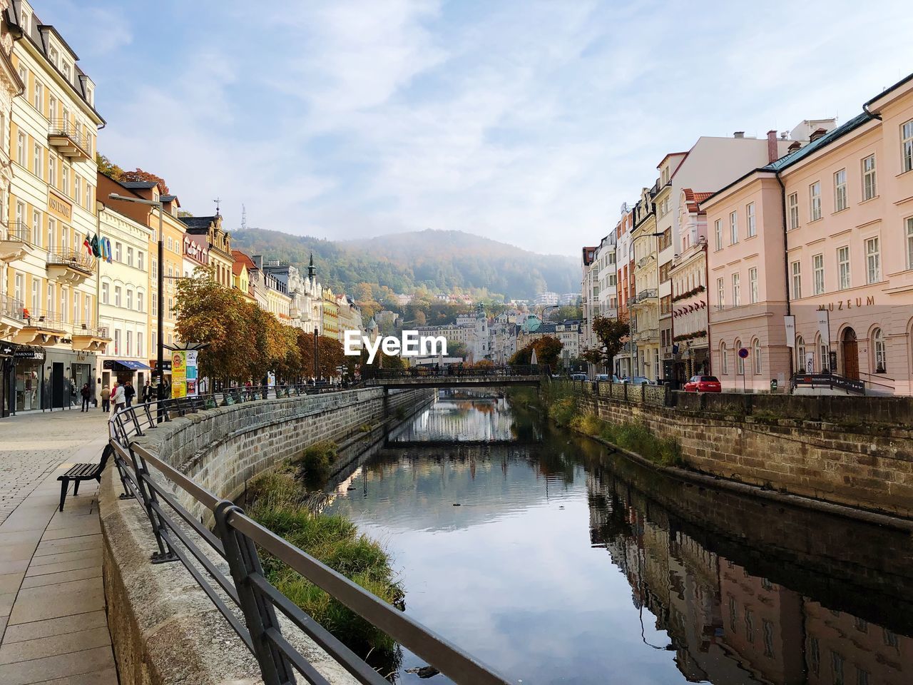 Bridge over canal amidst buildings in city against sky