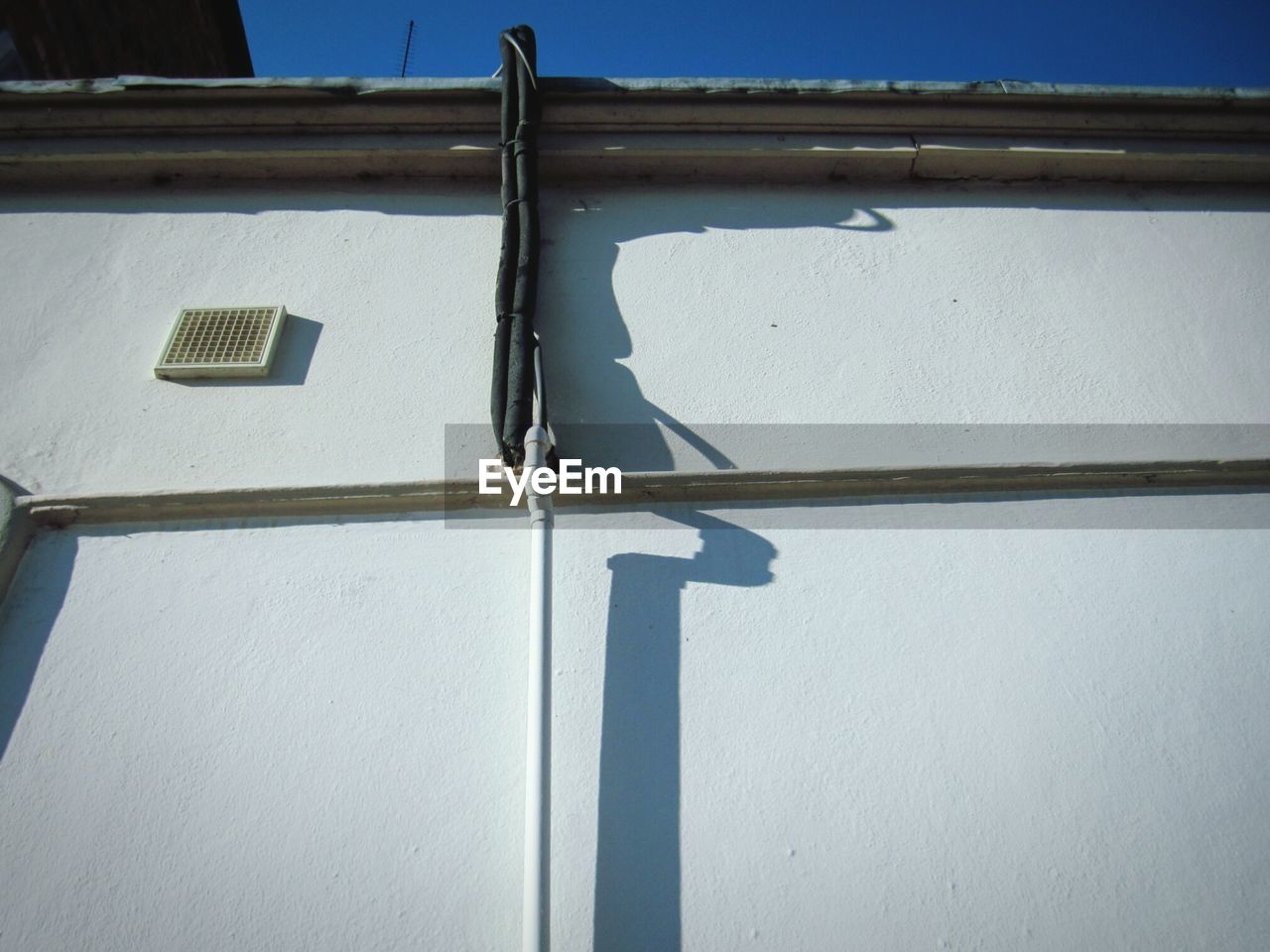 LOW ANGLE VIEW OF WHITE BUILDING AGAINST BLUE SKY