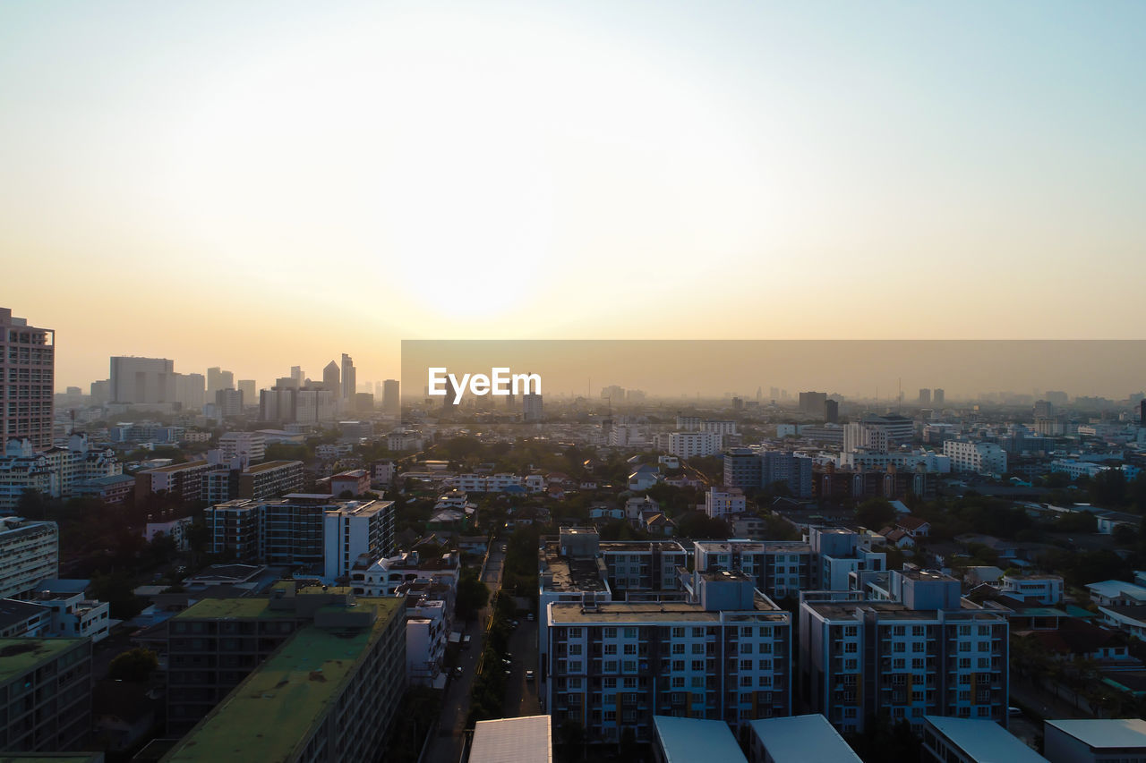 HIGH ANGLE VIEW OF CITY AGAINST SKY DURING SUNSET