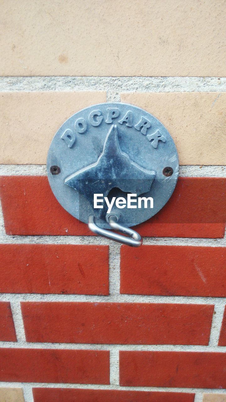 Close-up of metallic hook on brick wall
