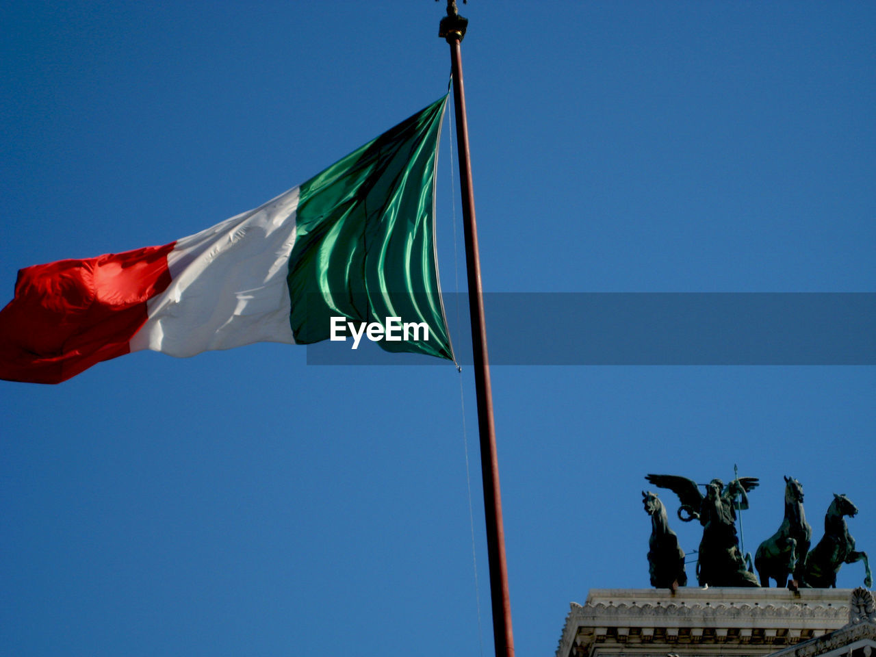 Low angle view of italian flag against clear blue sky