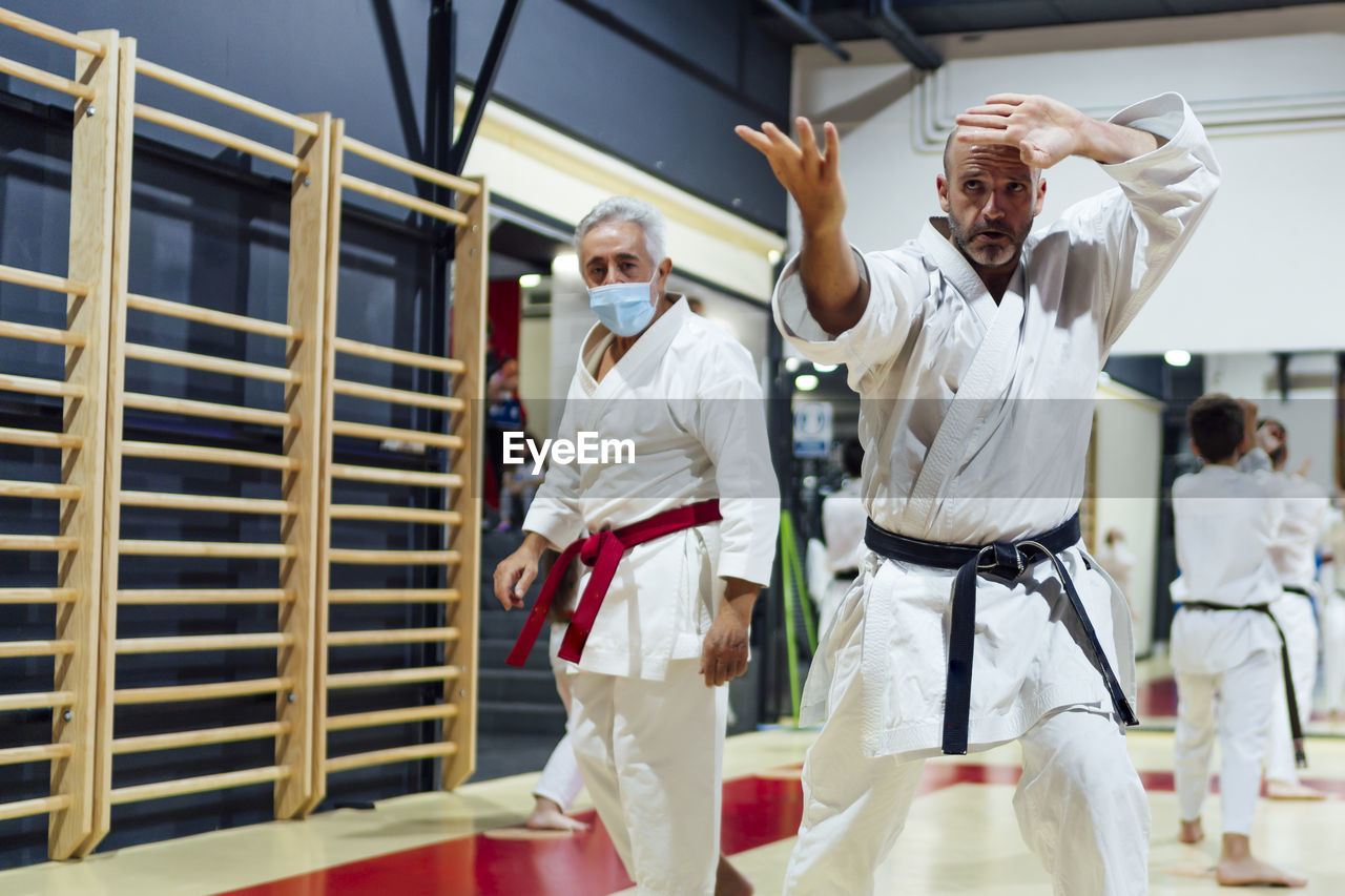 Instructor by male student practicing karate in class