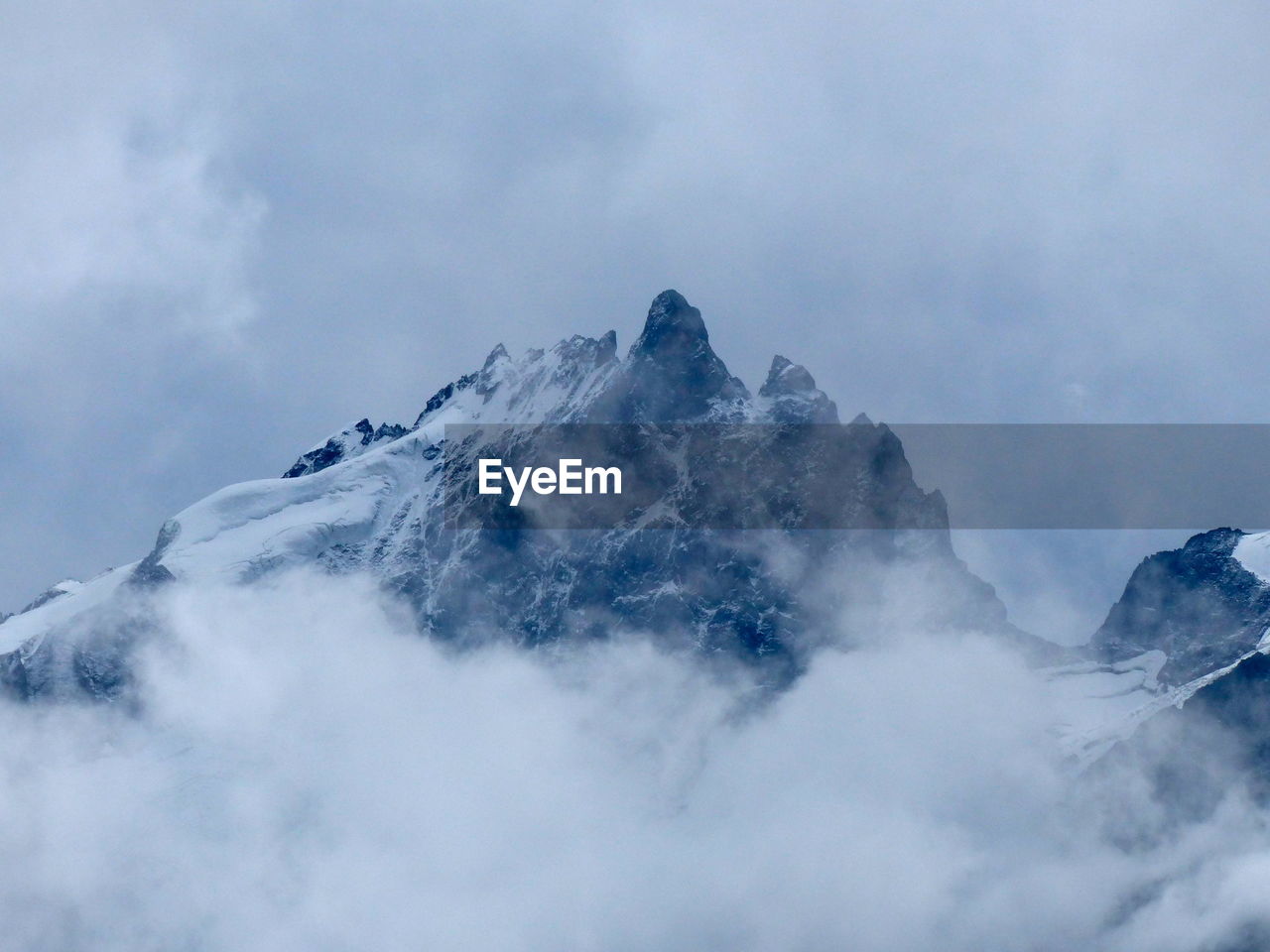 Low angle view of snow covered mountain against sky