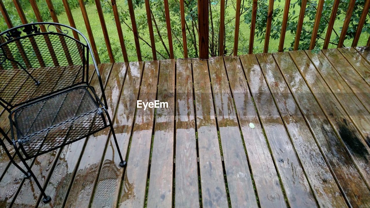 High angle view of chair on wet balcony