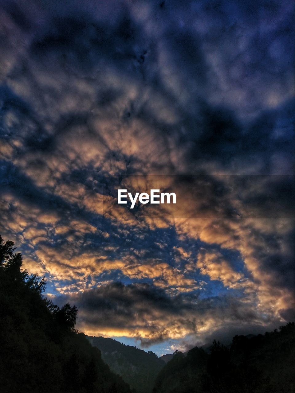 LOW ANGLE VIEW OF DRAMATIC SKY OVER SILHOUETTE MOUNTAIN