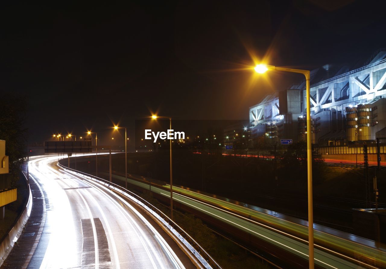 LIGHT TRAILS ON STREET AT NIGHT