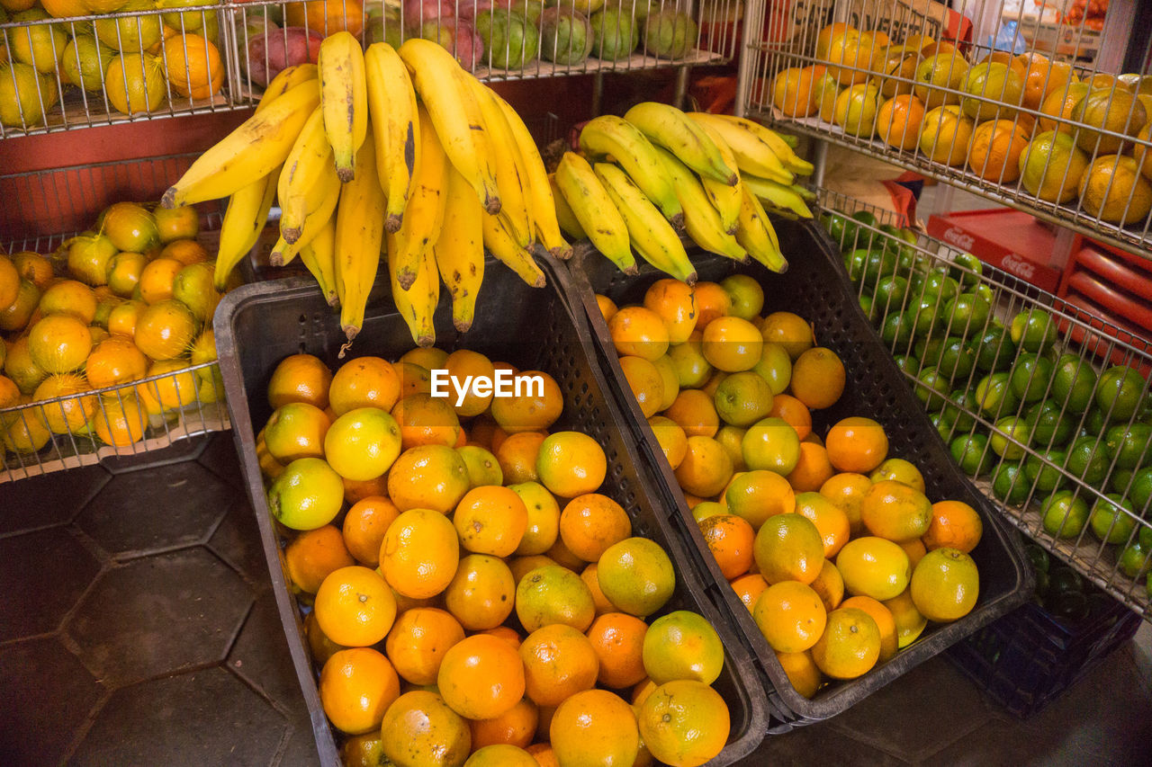 High angle view of fruits for sale at market stall. oranges and bananas