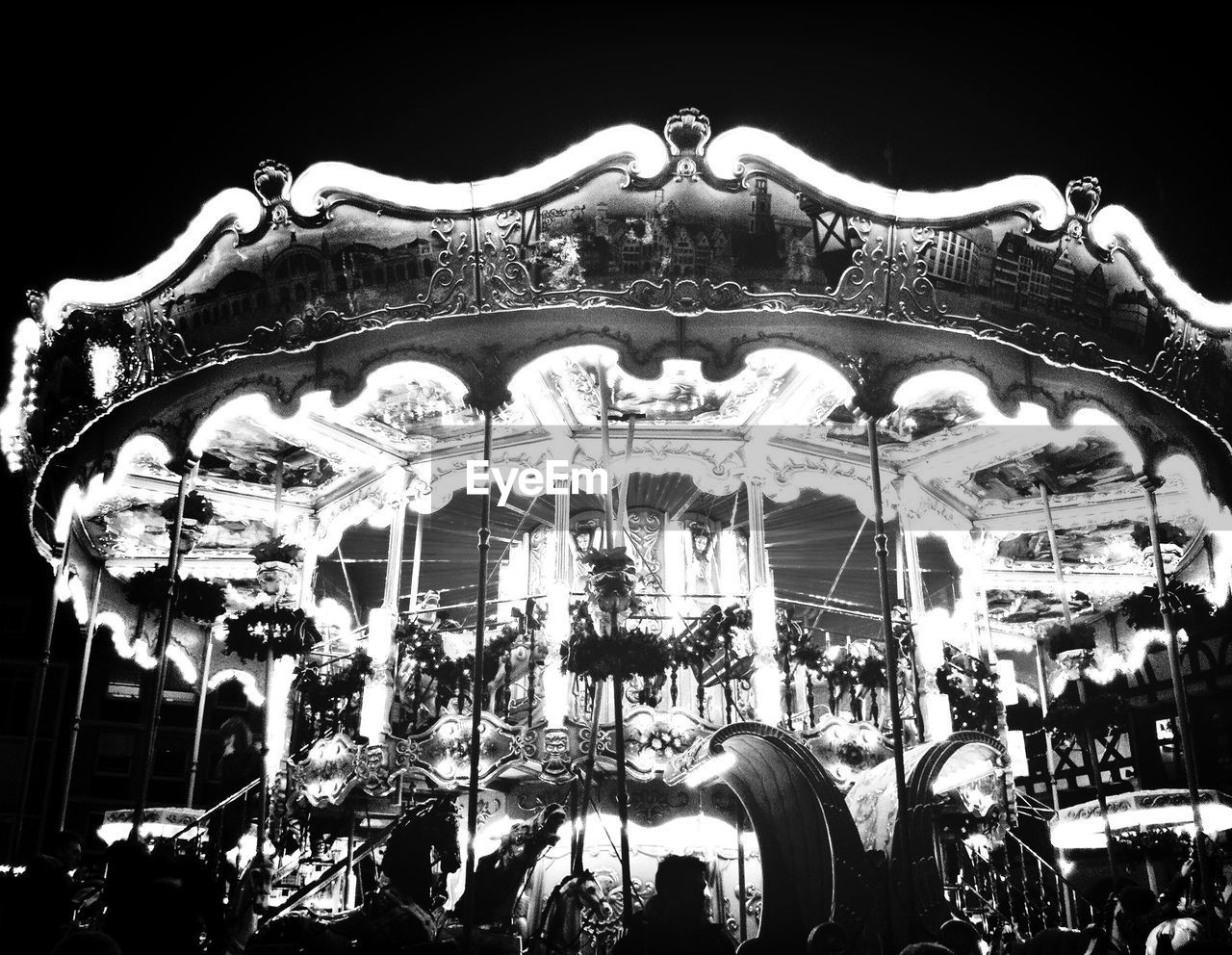 Low angle view of illuminated carousel in park against sky