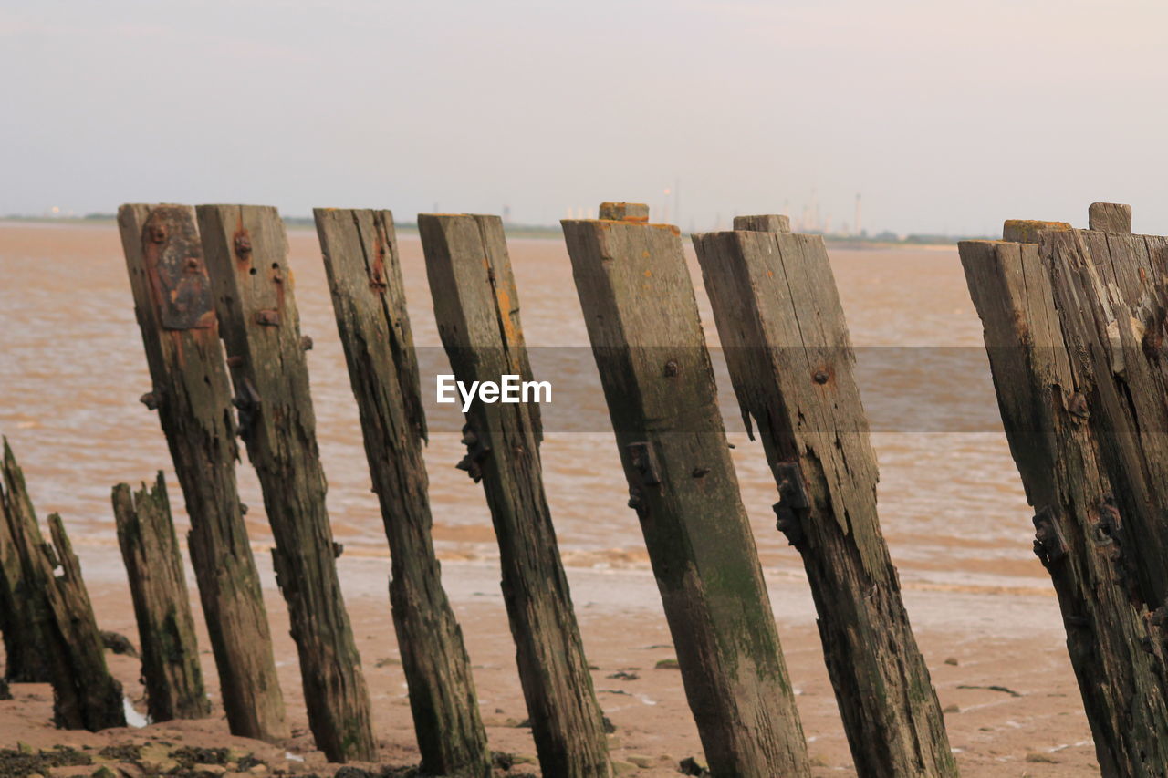 Wooden posts on beach