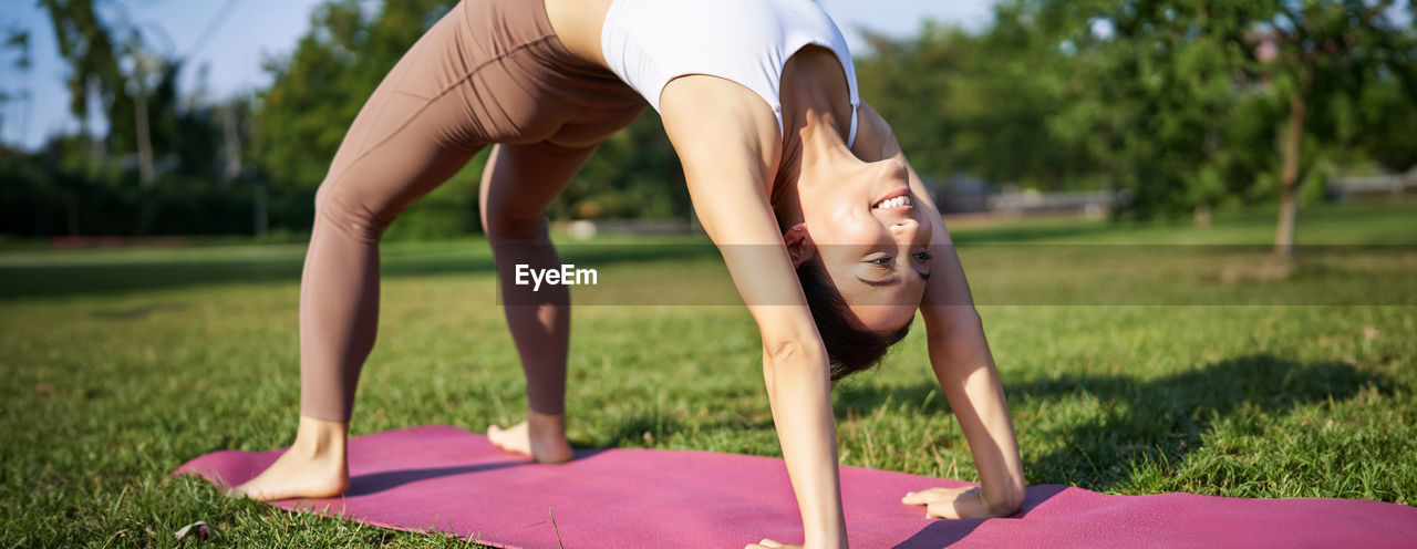 low section of young woman exercising on field