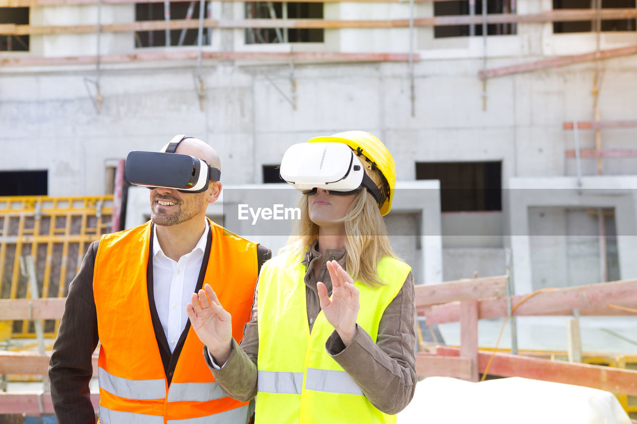 Two persons with virtual reality glasses at construction site