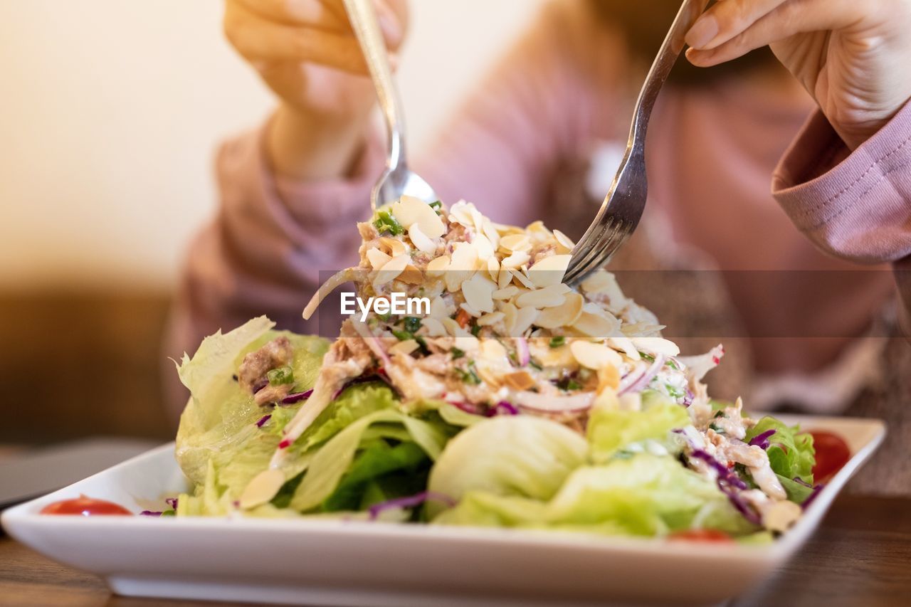 Midsection of woman eating food on table