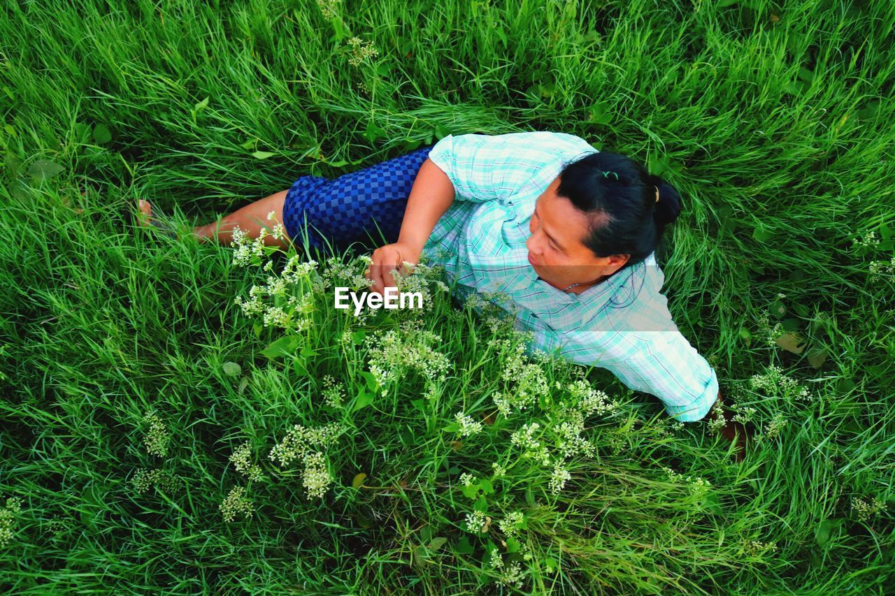 High angle view of woman sitting on grassy field