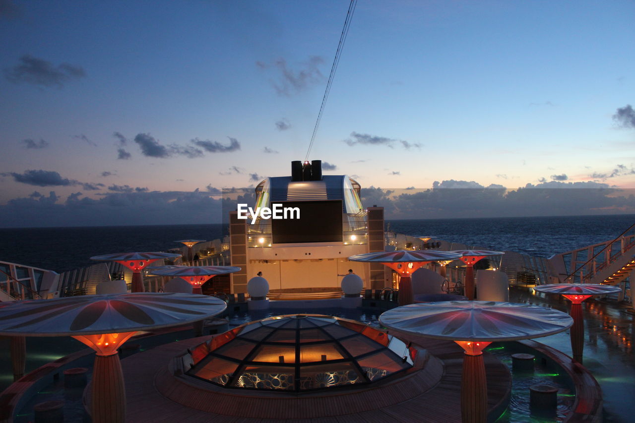 PANORAMIC VIEW OF ILLUMINATED SEA AGAINST SKY DURING SUNSET