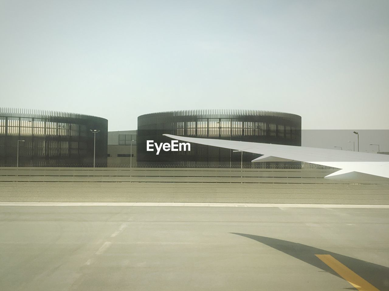 Cropped image of airplane at airport against clear sky