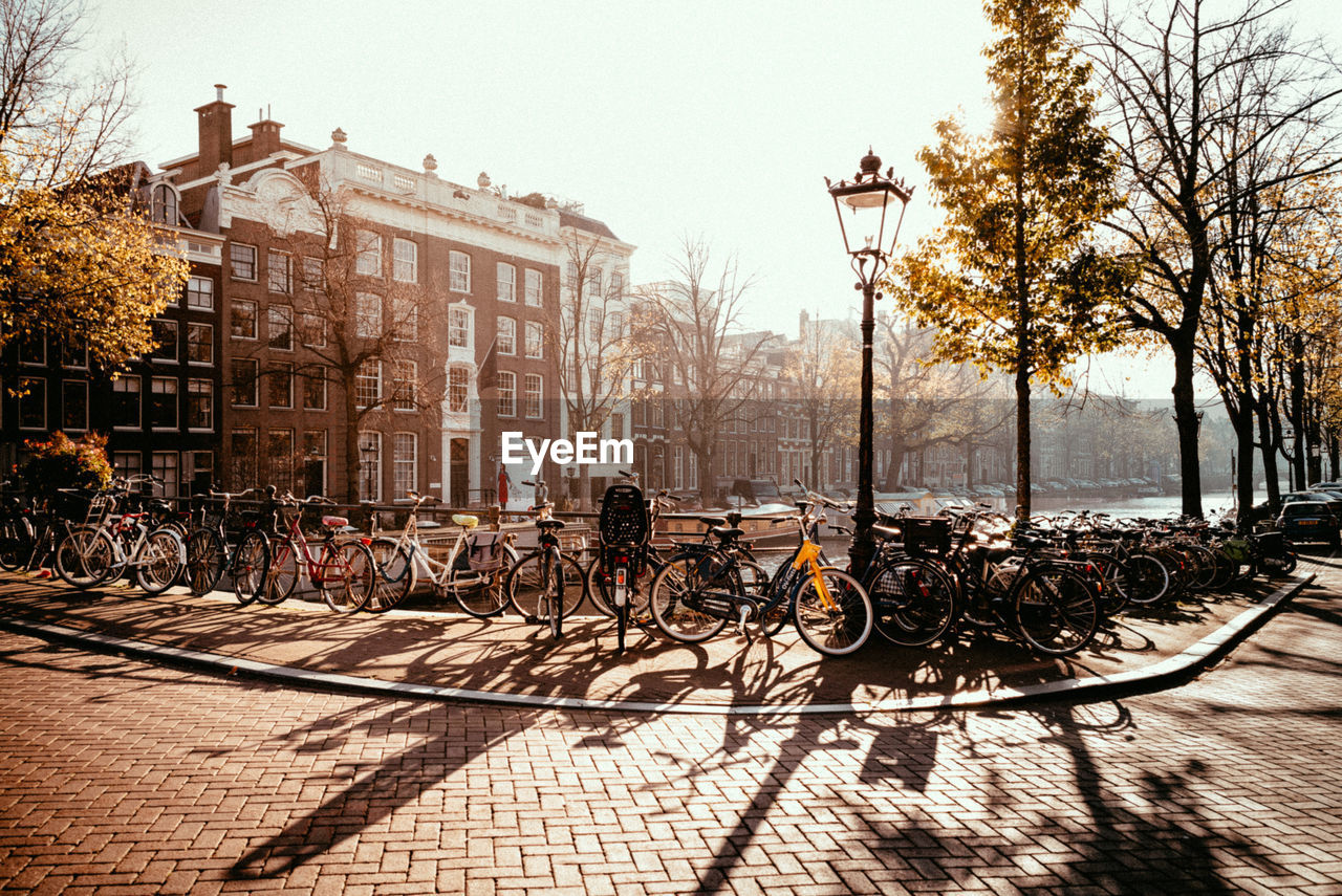 BICYCLES ON STREET BY BUILDINGS AGAINST SKY