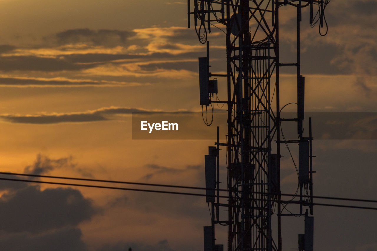 Low angle view of silhouette electricity pylon against sky during sunset