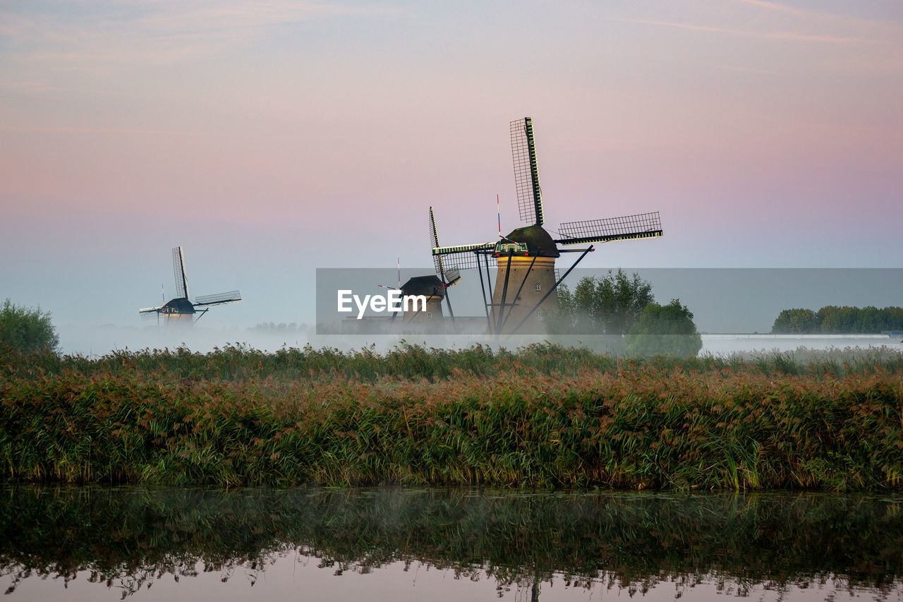 Traditional windmill on field against sky