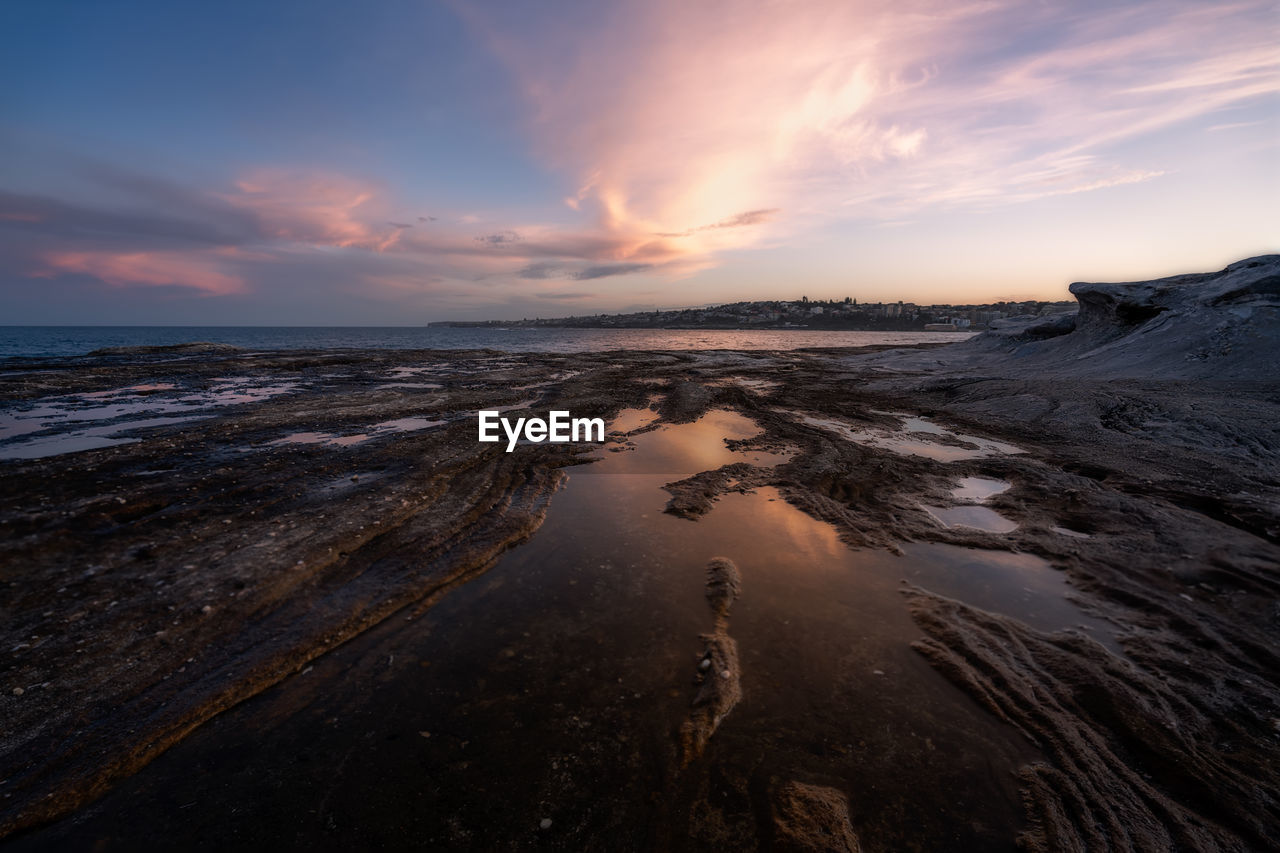 Scenic view of beach against sky during sunset