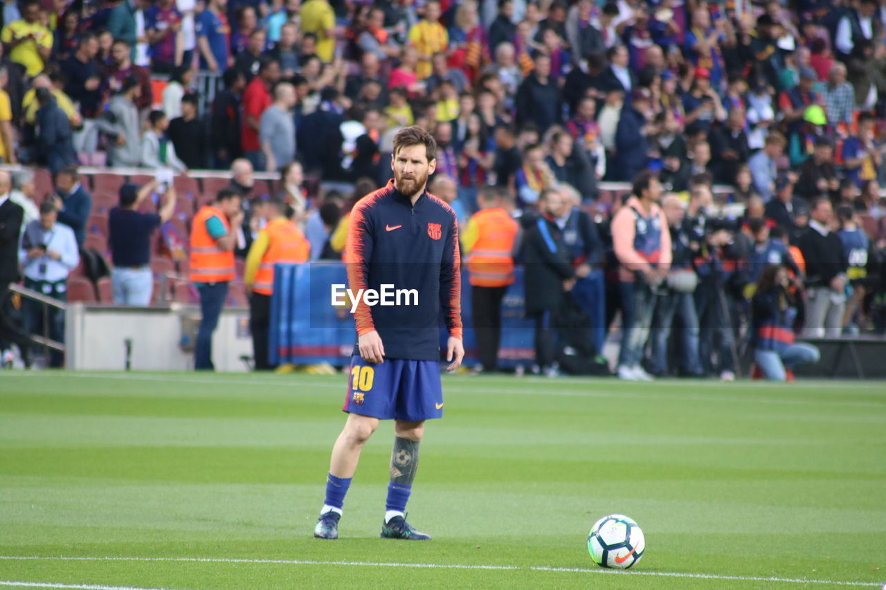 PEOPLE PLAYING SOCCER BALL ON FIELD