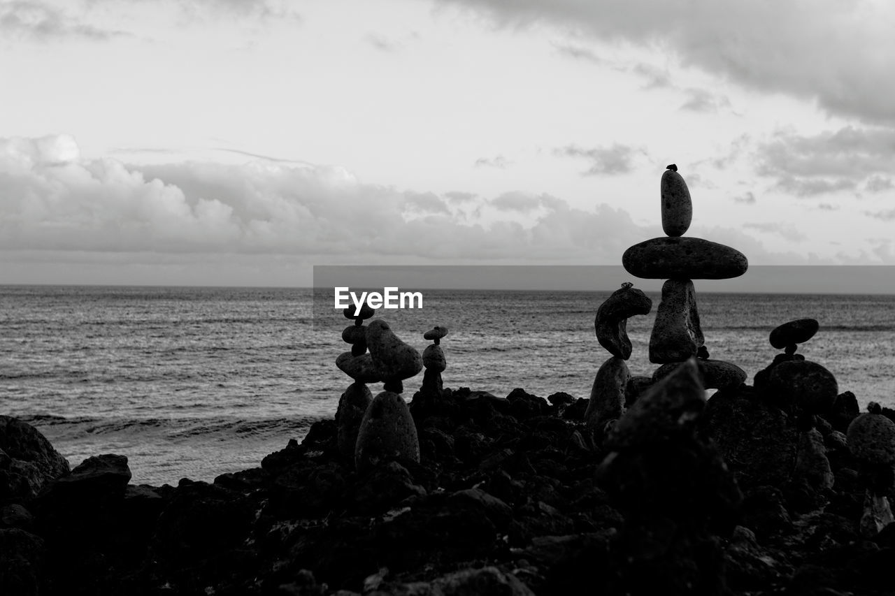 Stack of rocks at beach against sky