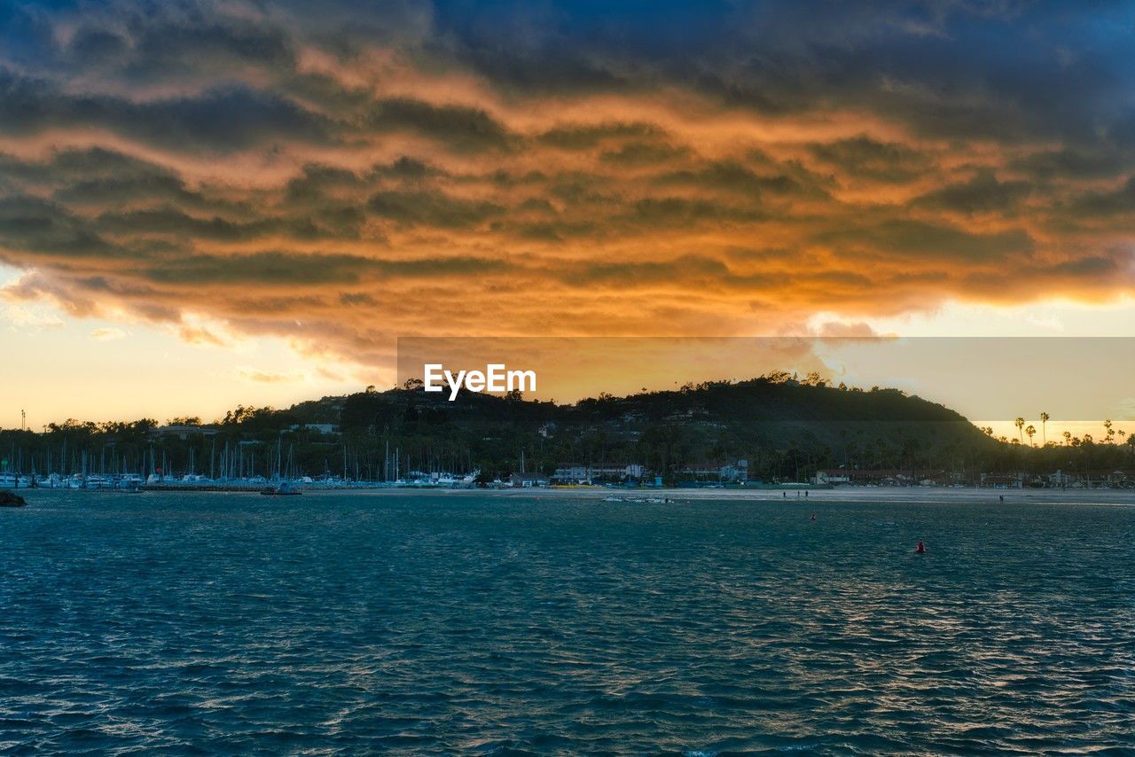 sky, water, cloud, sea, horizon, scenics - nature, beauty in nature, dusk, nature, sunset, shore, evening, environment, land, tranquility, tree, landscape, tranquil scene, ocean, body of water, travel destinations, no people, outdoors, travel, coast, beach, idyllic, reflection, plant, wave, seascape, blue, dramatic sky, sunlight, island, vacation, bay, trip, holiday, tourism, mountain, architecture, sun, coastline