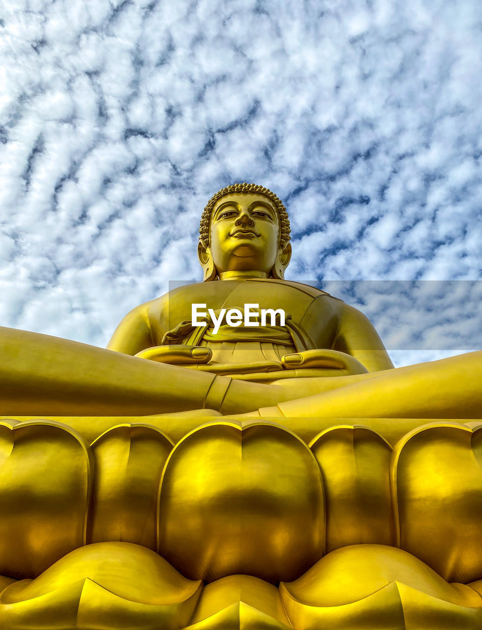 Low angle view of buddha statue against sky