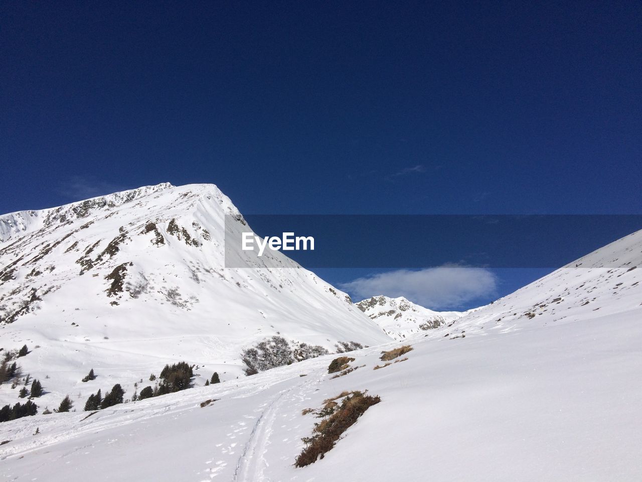 Scenic view of snowcapped mountains against clear blue sky