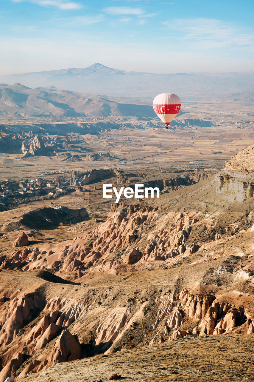 Aerial view of hot air balloon flying over landscape