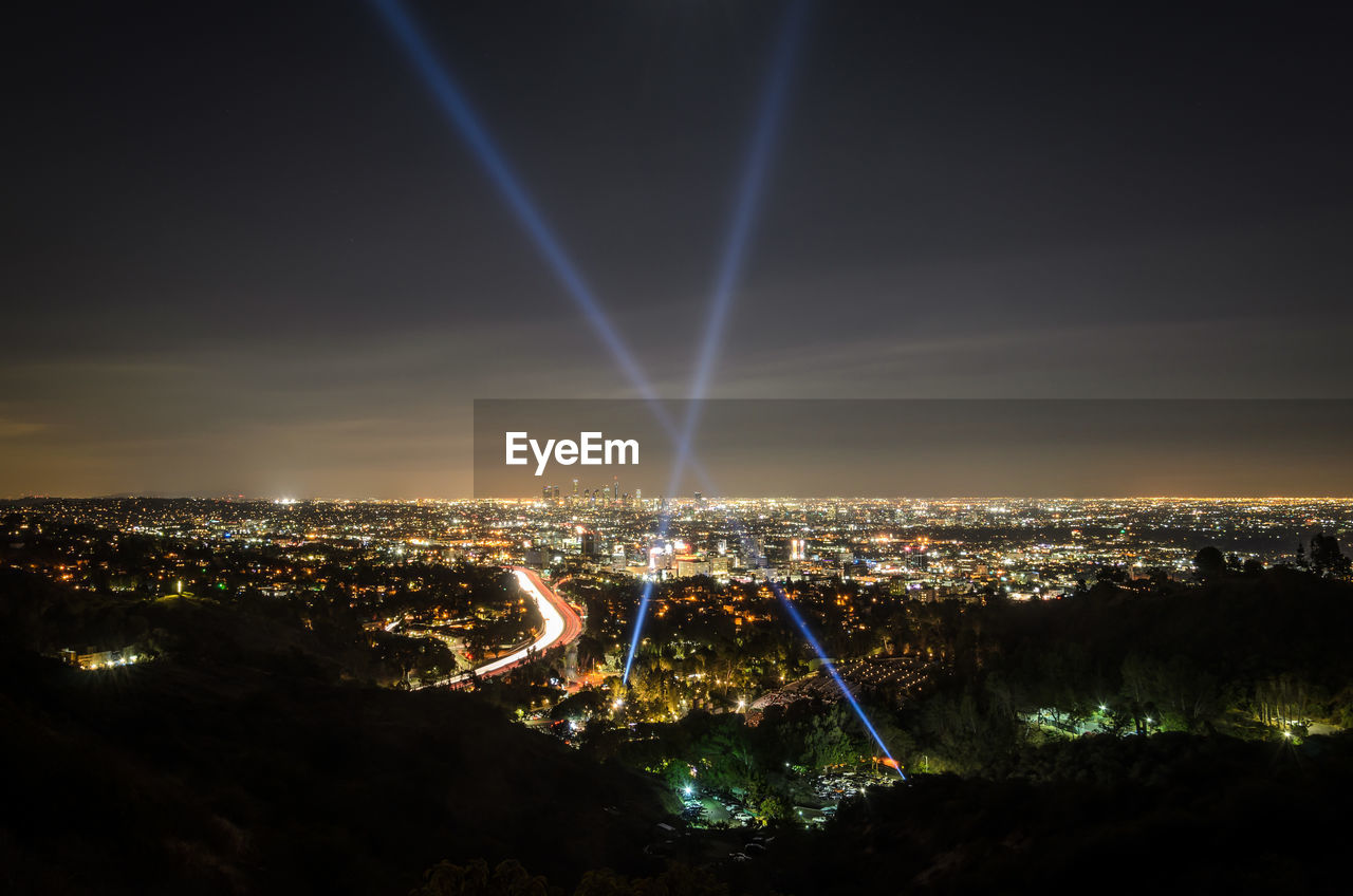 Illuminated cityscape against sky at night