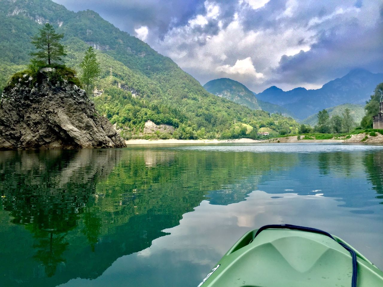 Scenic view of lake by mountains against sky