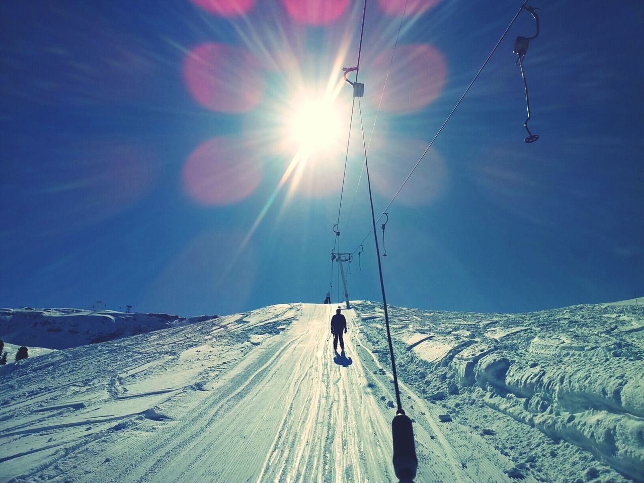 Scenic view of snowy field against bight sun