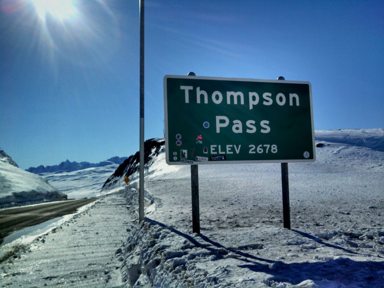 Information sign on snow covered mountain against clear sky