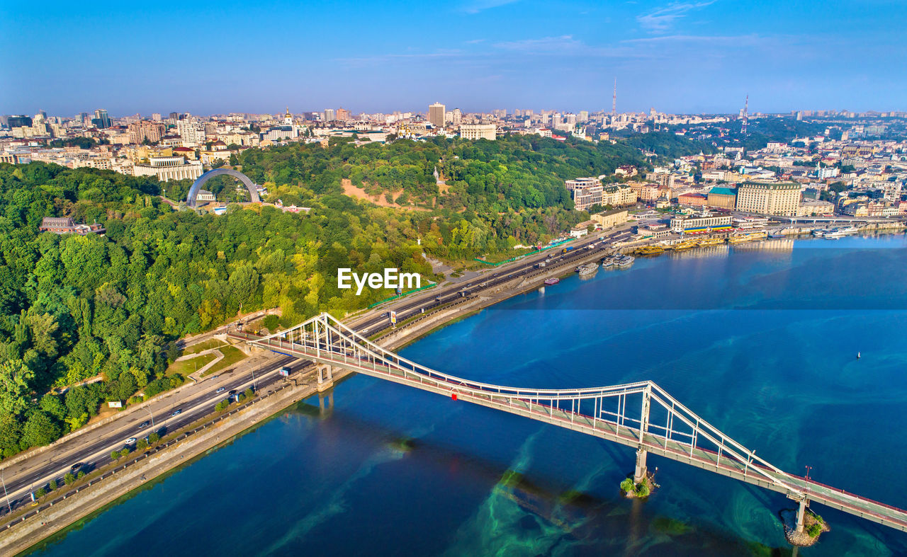HIGH ANGLE VIEW OF BRIDGE OVER RIVER AGAINST CITYSCAPE