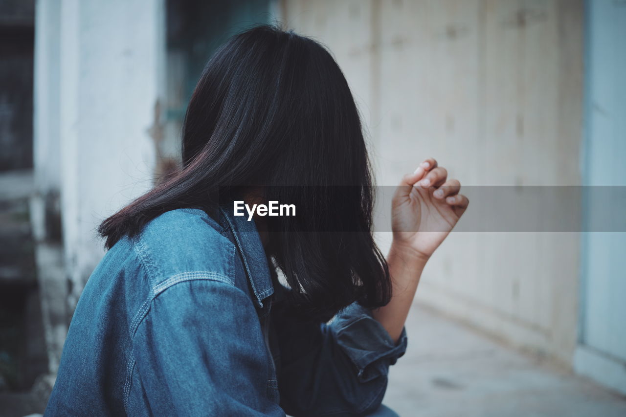 Side view of woman wearing denim jacket