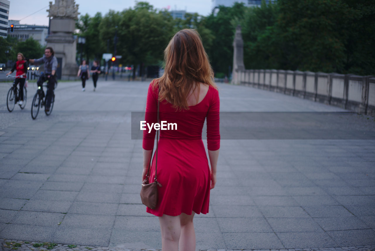 Rear view of woman walking on footpath