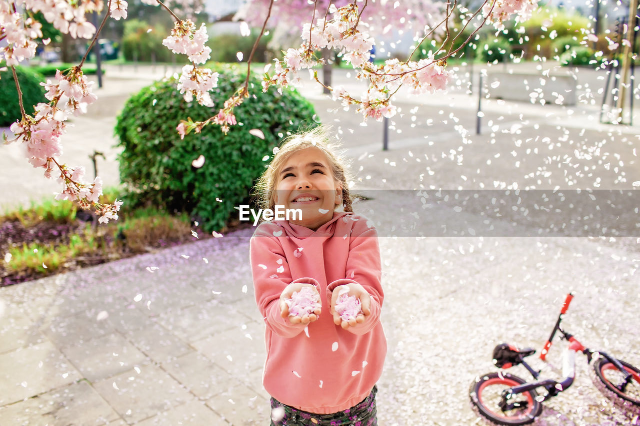 Cute girl playing amidst flower petals